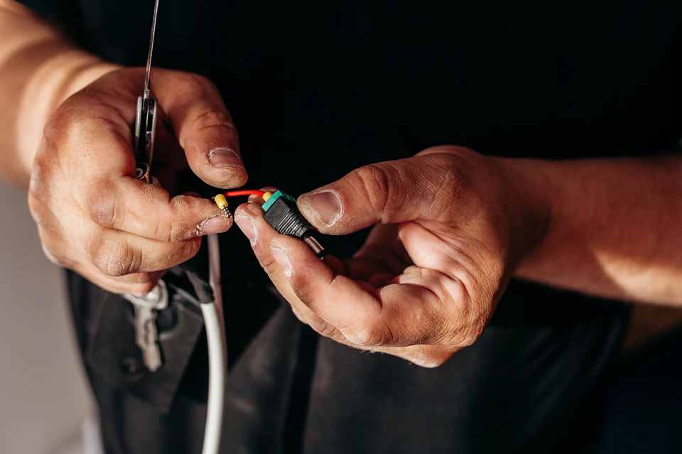 Gros plan sur une poign&eacute;e de main du charpentier &eacute;lectricien tenant un casque et des lunettes de protection &agrave; la main
