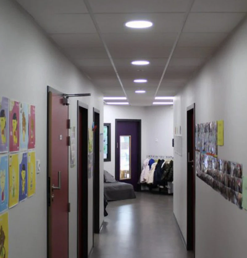 Salle de réunion contemporaine avec grande table en bois massif et chaises design disposées symétriquement